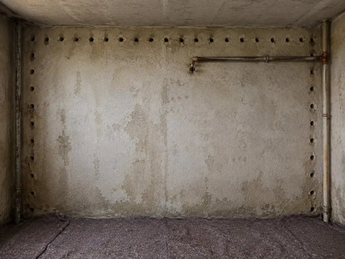 Vorher: Kellerwand mit Bohrlochreihen der Horizontalsperre vor und nach der Sanierung